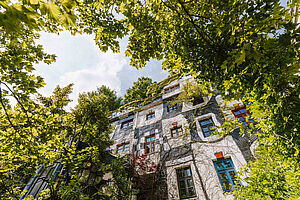 Foto vom Fassade des Kunst Haus Wien im Sonnenschein, mit grünen Bäumen