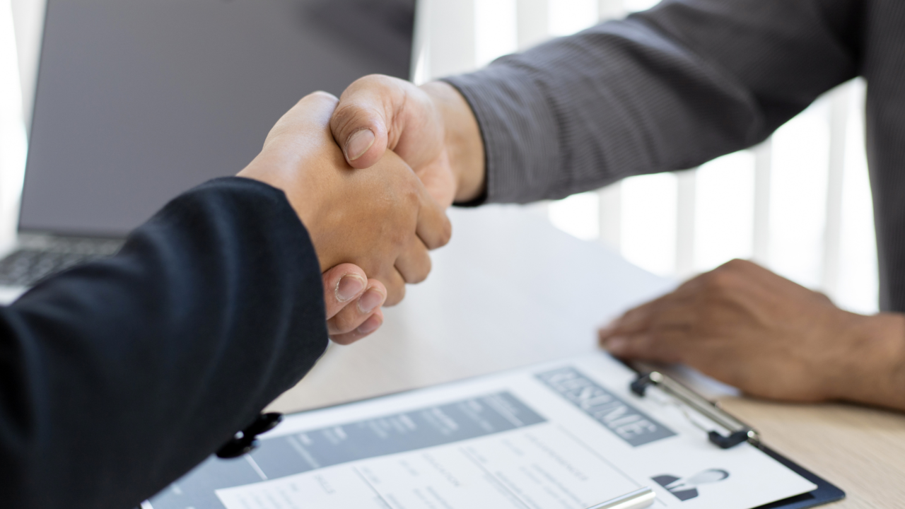 Zwei Personen geben sich nach einem Bewerbungsgespräch die Hand