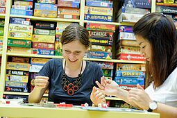 Spielenacht Zwei junge Frauen spielen ein Brettspiel.