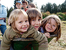 Herbst Kinder lassen sich in einer Schubkarre führen.