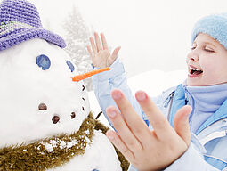 Kind mit Schneemann