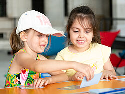 Zwei Kinder sehen sich eine Spielkarte an.