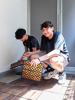 EAW Schüler verlegen einen Terrassenboden.