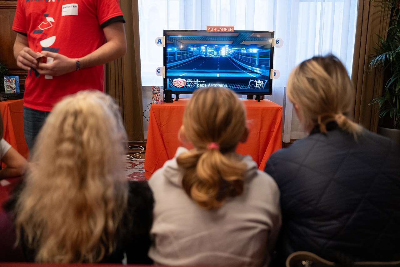 GAME CITY 2024 Kinder spielen im Rathaus an einer Konsole