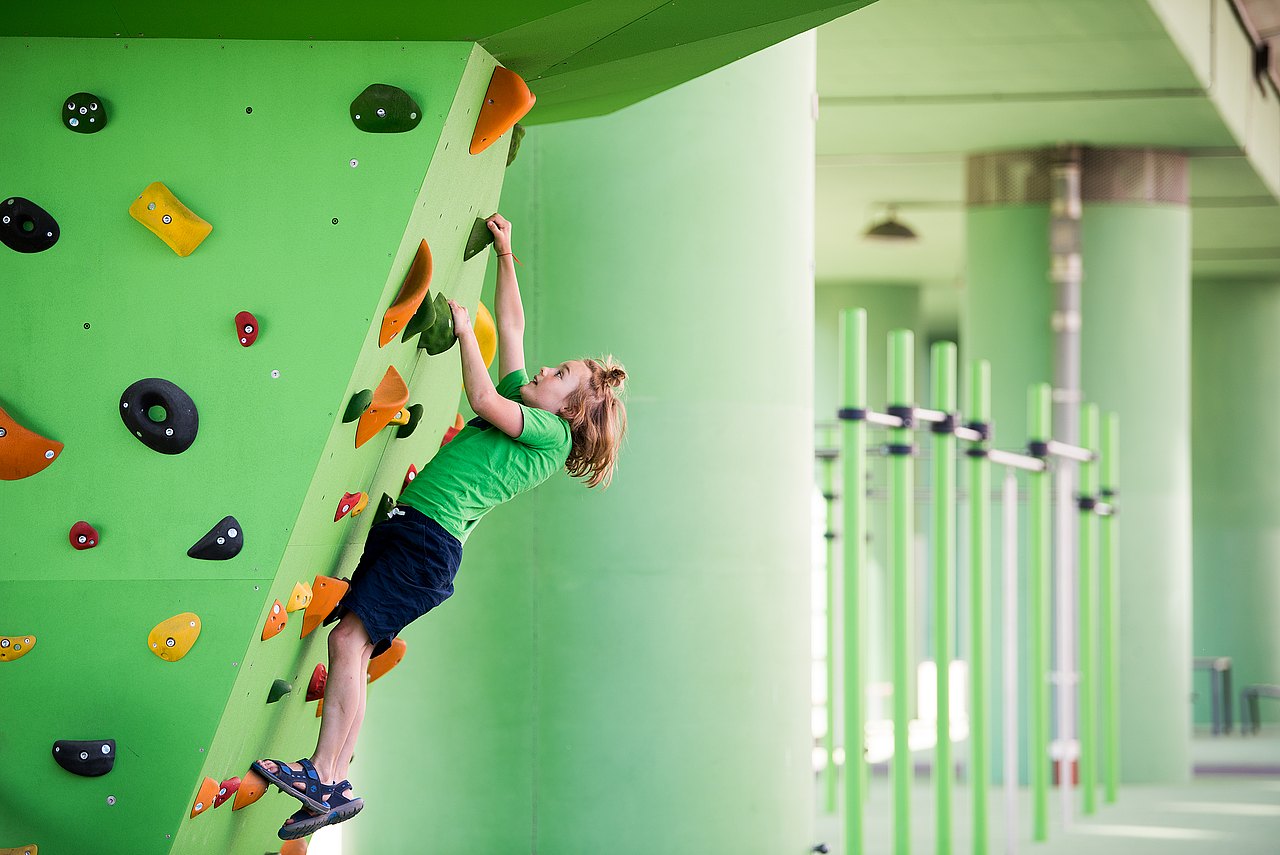 3465_© Barbara Mair Kind klettert auf Klettergriffen draußen