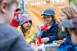 Ostern Ein Gruppe von Kindern spielt im Freien ein lustiges Brettspiel.