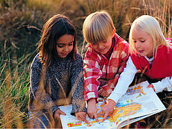 Kinder im Herbstgras 3 Kinder spielen im Herbstgras