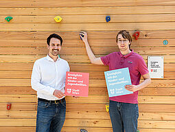 Kletterwand Vizebürgermeister C. Wiederkehr und Ideeneinreicher Alexander Windhab stehen vor der Kletterewand.