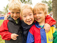Drei Kinder Drei Kinder lachen in die Kamera.