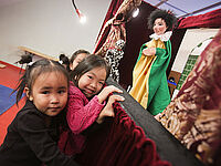 Kasperlbühne mit 2 Mädchen davor