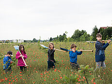 Kinder mit Schaufeln und Spaten in der Wiese