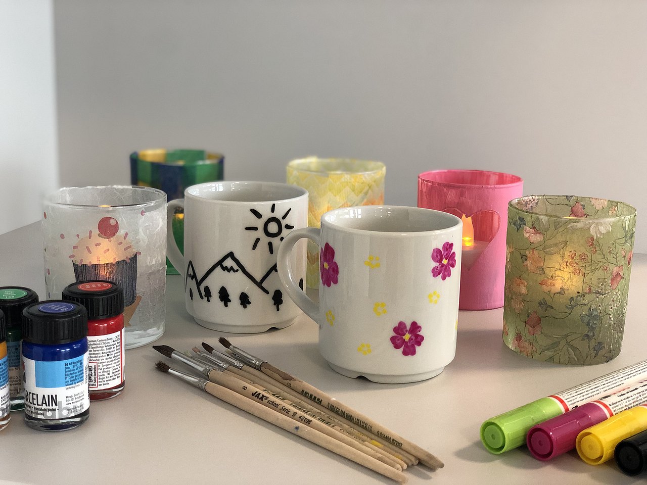 Bemalte Tassen mit Malutensilien