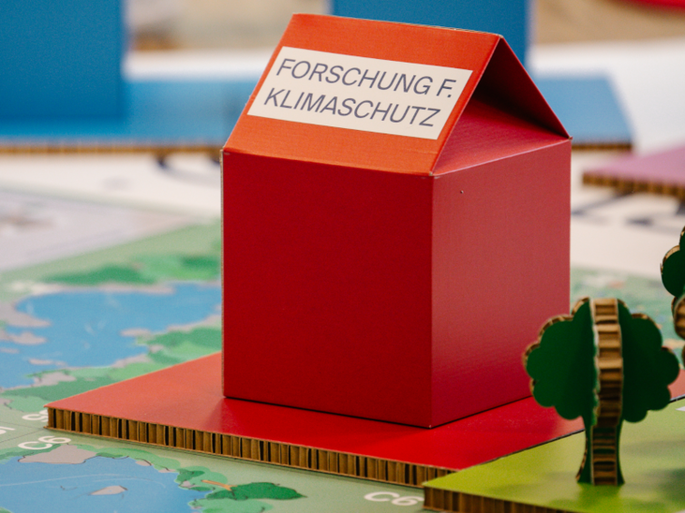 Rotes Häuschen mit Text "Forschung für Klimaschutz"