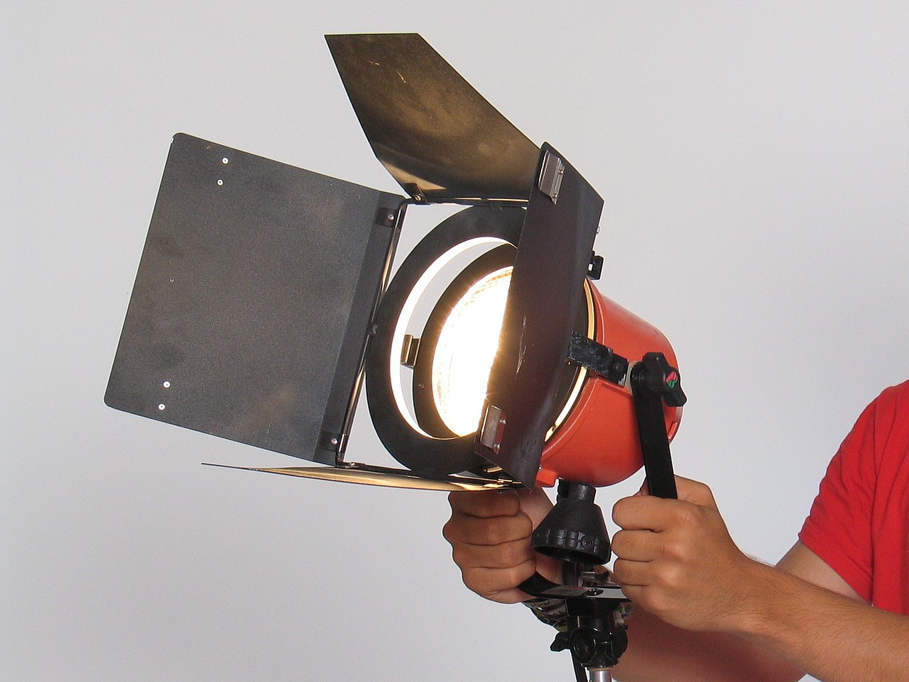 Ein Jugendlicher hält eine kleine Videoleuchte mit Torblenden in der Hand.