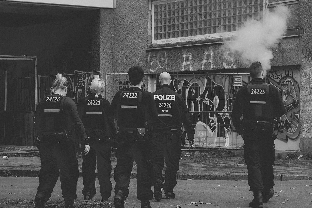 Polizei Polizeibeamte von hinten auf grauem Bild ohne Farbe