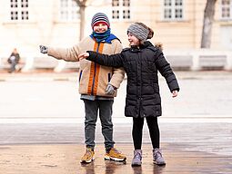 Ferienspiel Ein Junge und ein Mädchen sind in der Stadt unterwegs.