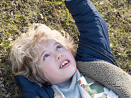 Natur_2 Bub liegt im Gras