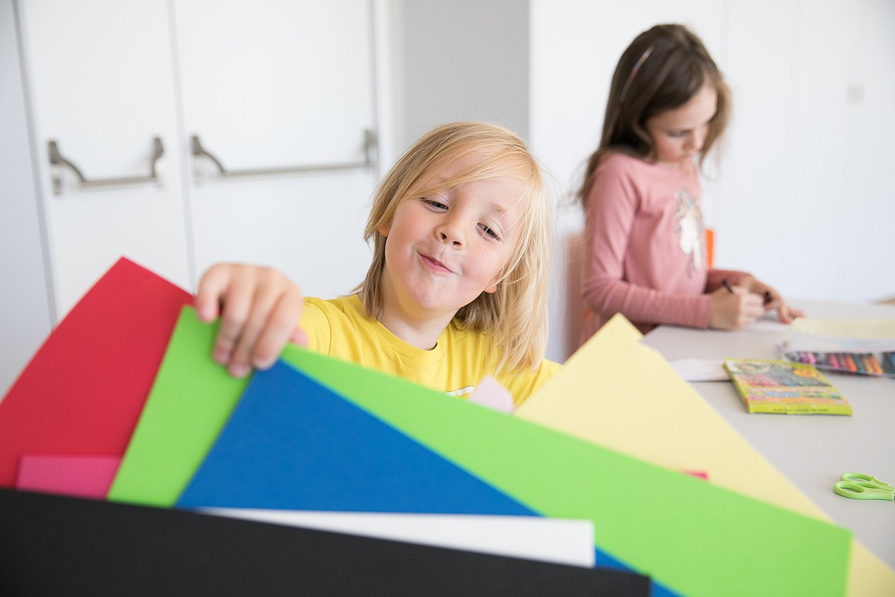 20210903_IMG_1557 Kind sucht sich ein buntes Blatt Papier zum Basteln aus