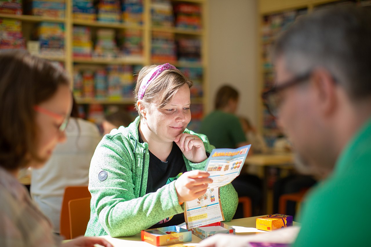 Spielebox Frau liest Spielanleitung
