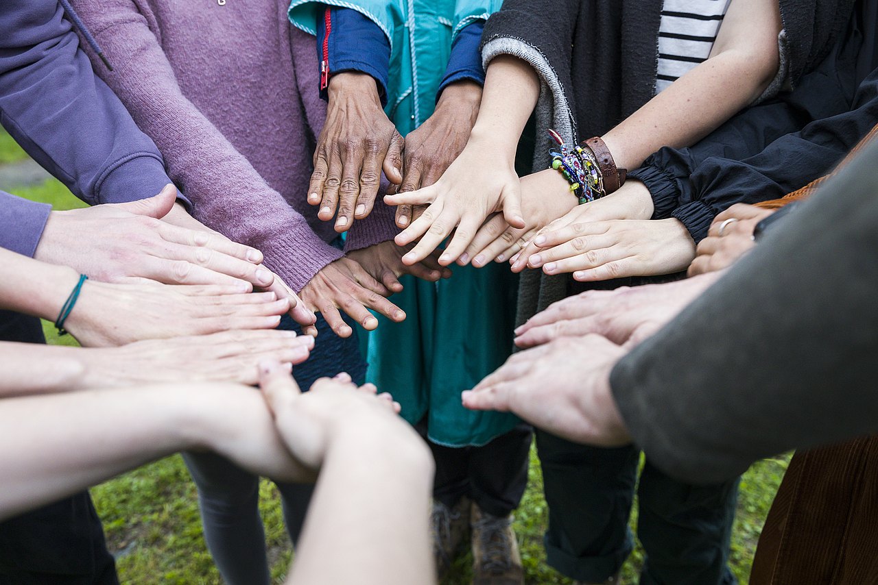 Lehrgang Grundkurs Jugendarbeit-(c)-Carolina Frank-_FR_3995 Verschiedene Hände, die in einem Kreis übereinandergelegt sind.