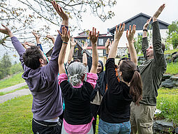 Gruppe von Jugendarbeiter_innen streckt Hände in die Höhe.