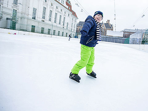 Bub mit grüner Hose beim Eislaufen Bub mit grüner Hose beim Eislaufen