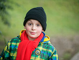 Bub im Herbst Bub mit Haube, Schal und Anorak in der Natur