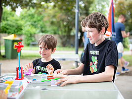 Zwei Kinder spielen Looping Louie im Park