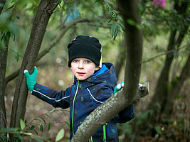 Bub im Anorak im herbstlichen Wald