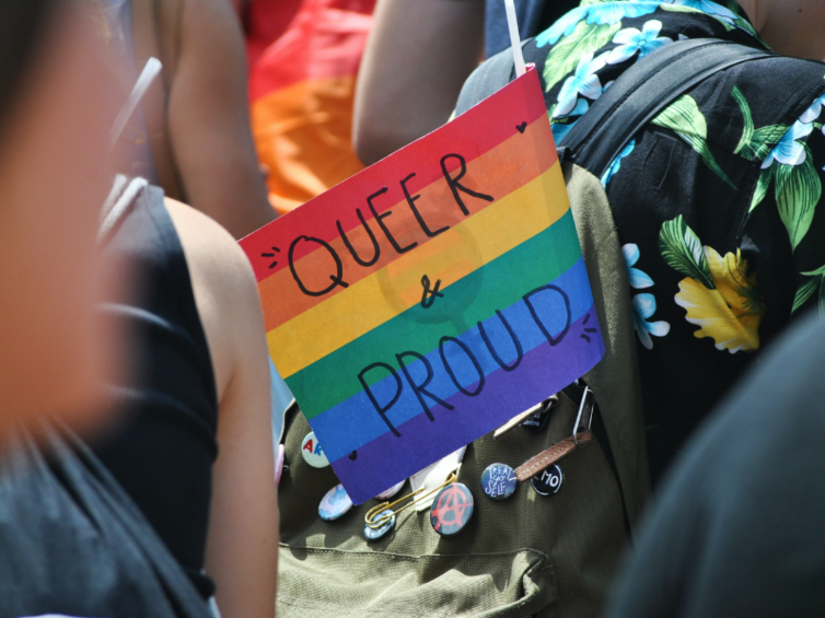 Regenbogenfahne mit Aufschrift "Queer & Proud"
