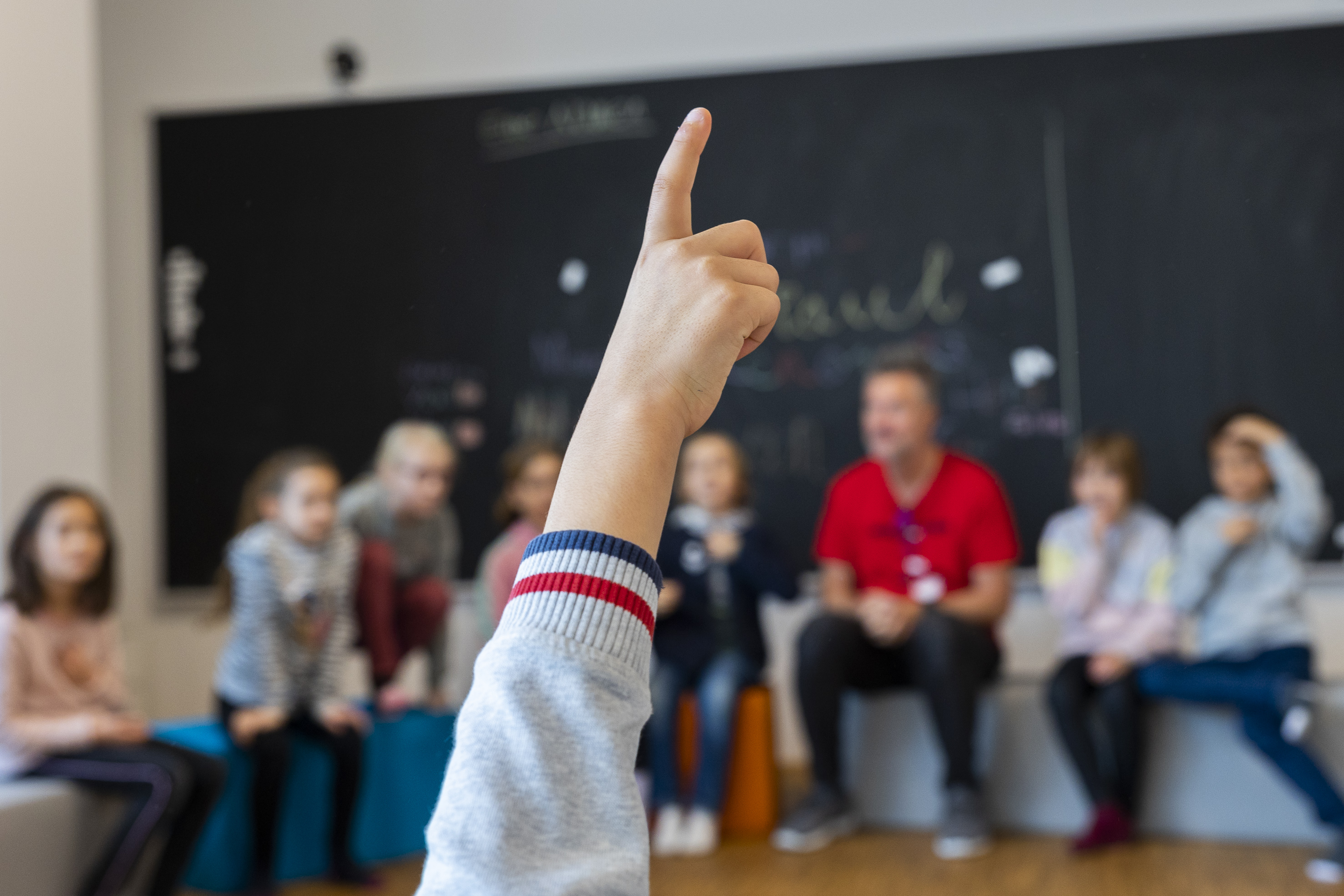 221117_2-11 Kind zeigt auf, dahinter sitzen weitere Kinder