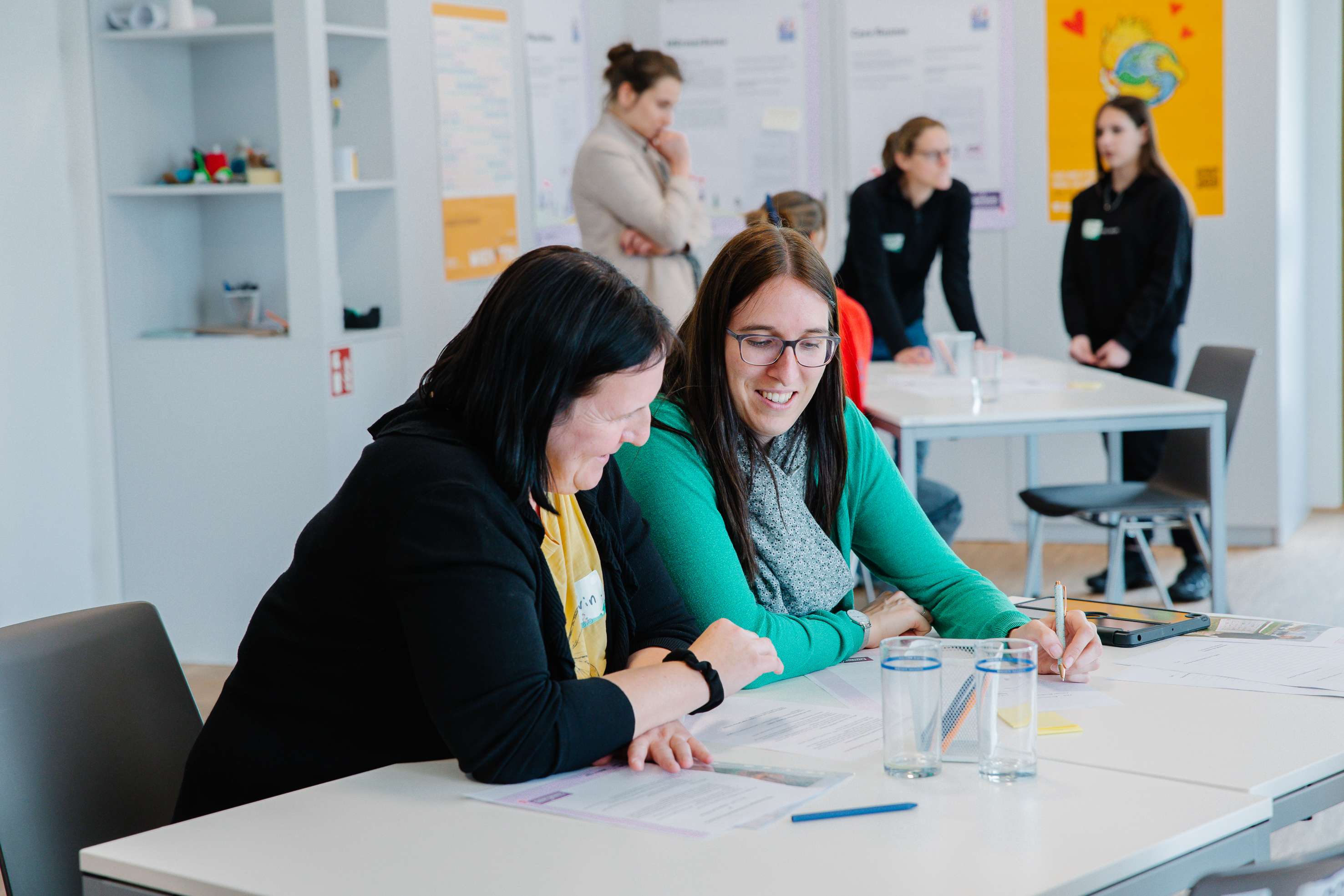 Junges Wien Personen sitzen an einem Tisch und besprechen sich