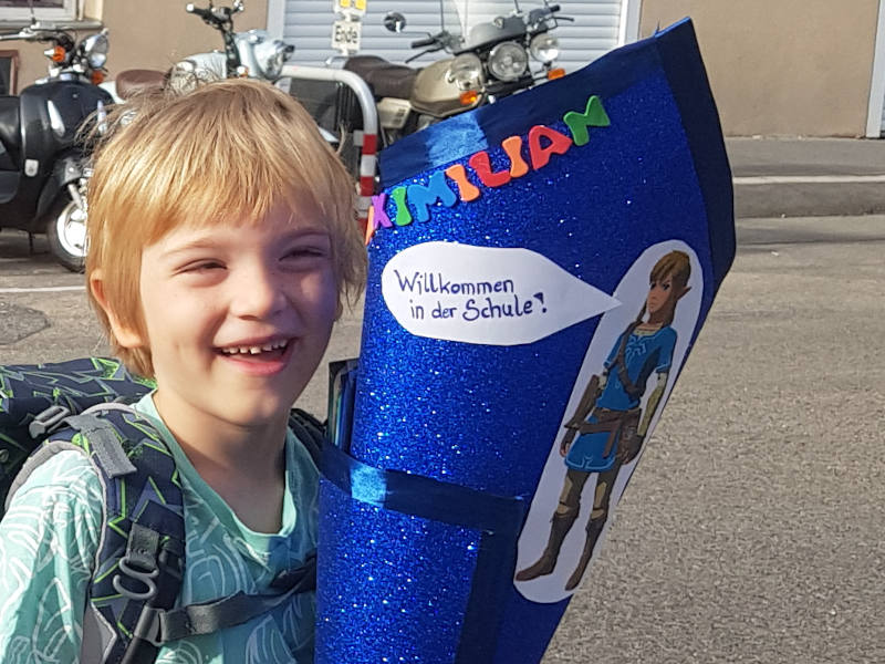 Schultüte lächelndes Kind mit blauer Schultüte