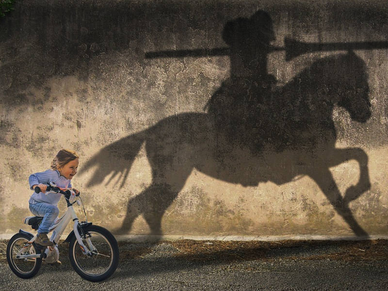 Kind am Fahrrad mit Pferd als Schatten