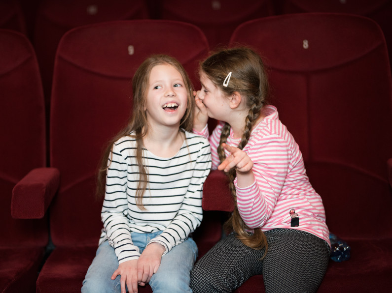 Mädchen flüstern im Theater