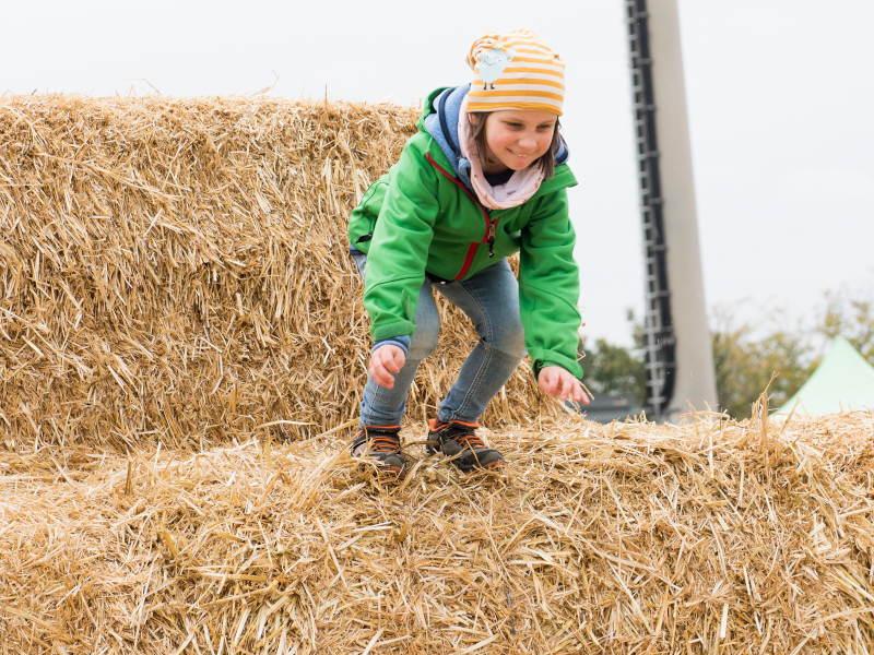 Kind auf Strohpyramide