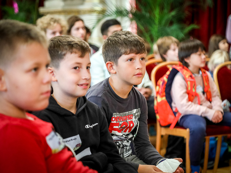 Drei Buben verfolgen gespannt das Plenum des Kinder- und Jugendparlaments.