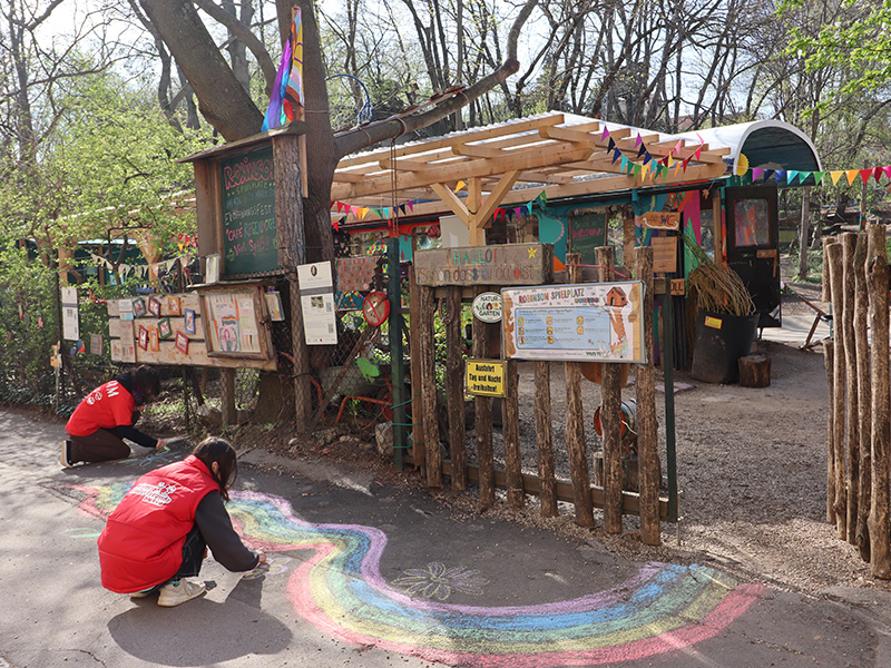 Regenbogen Zwei Jugendliche malen bunte Regenbögen mit Kreide vor dem Cafe Regenbogen.