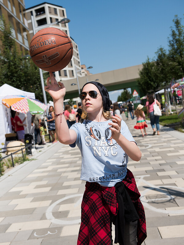 Mädchen balanciert Basketball auf Finger.