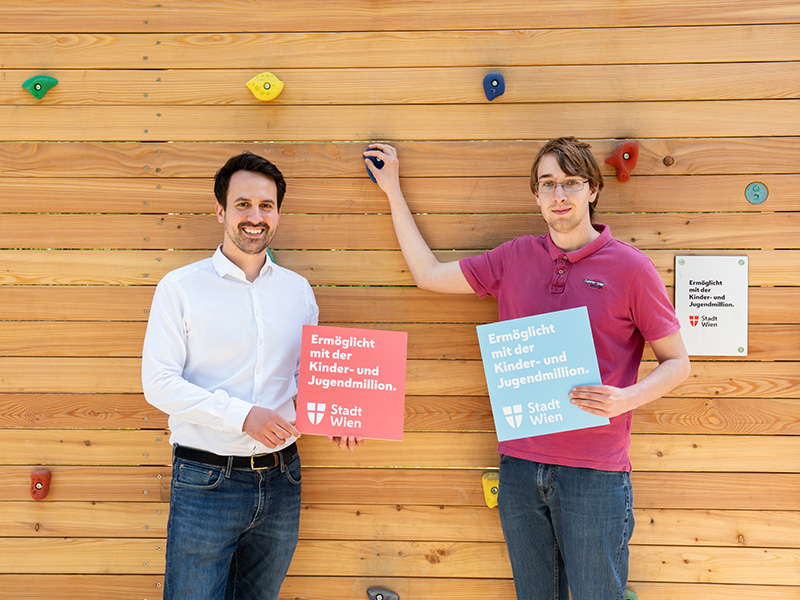 Kletterwand Vizebürgermeister C. Wiederkehr und Ideeneinreicher Alexander Windhab stehen vor der Kletterewand.