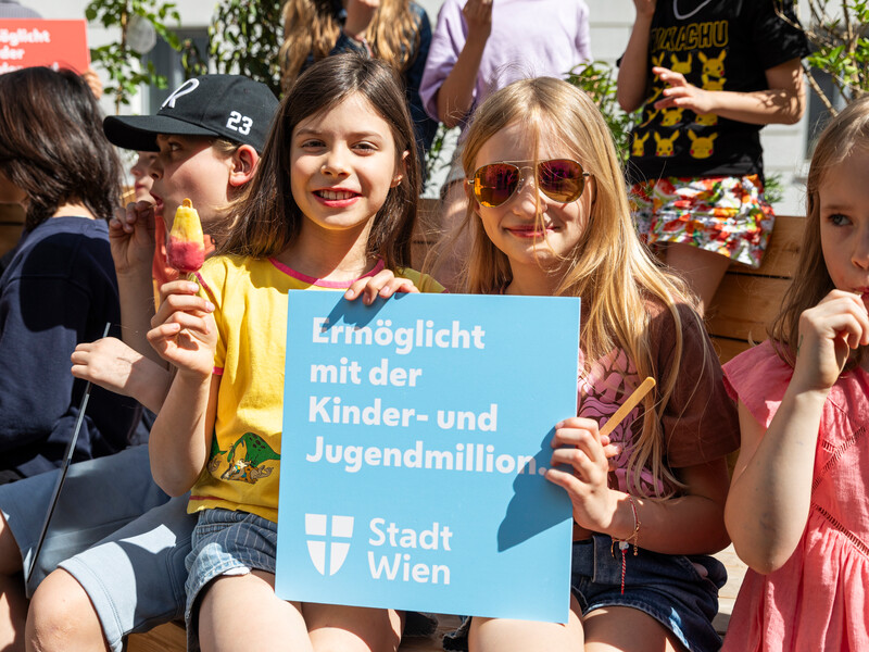 Zwei Schülerinnen sitzen im Parklet und essen ein Eis.