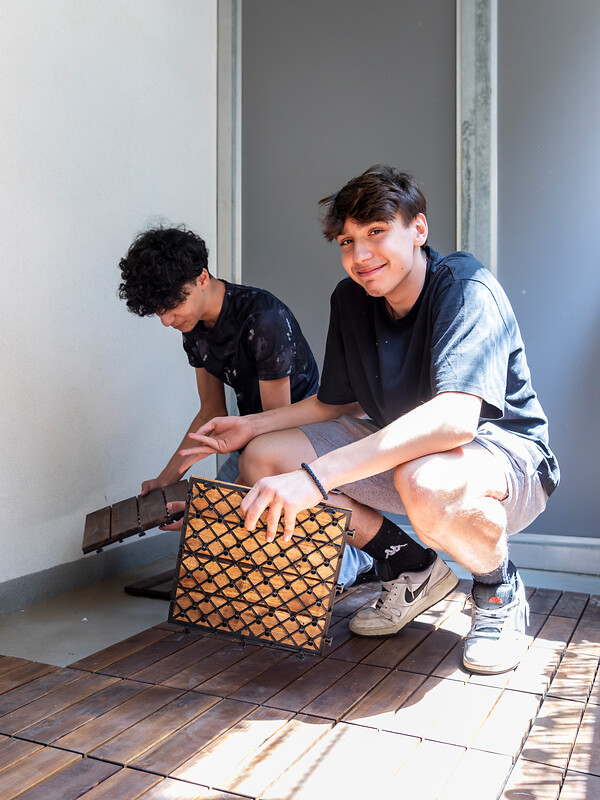 Schüler verlegen einen Terrassenboden.